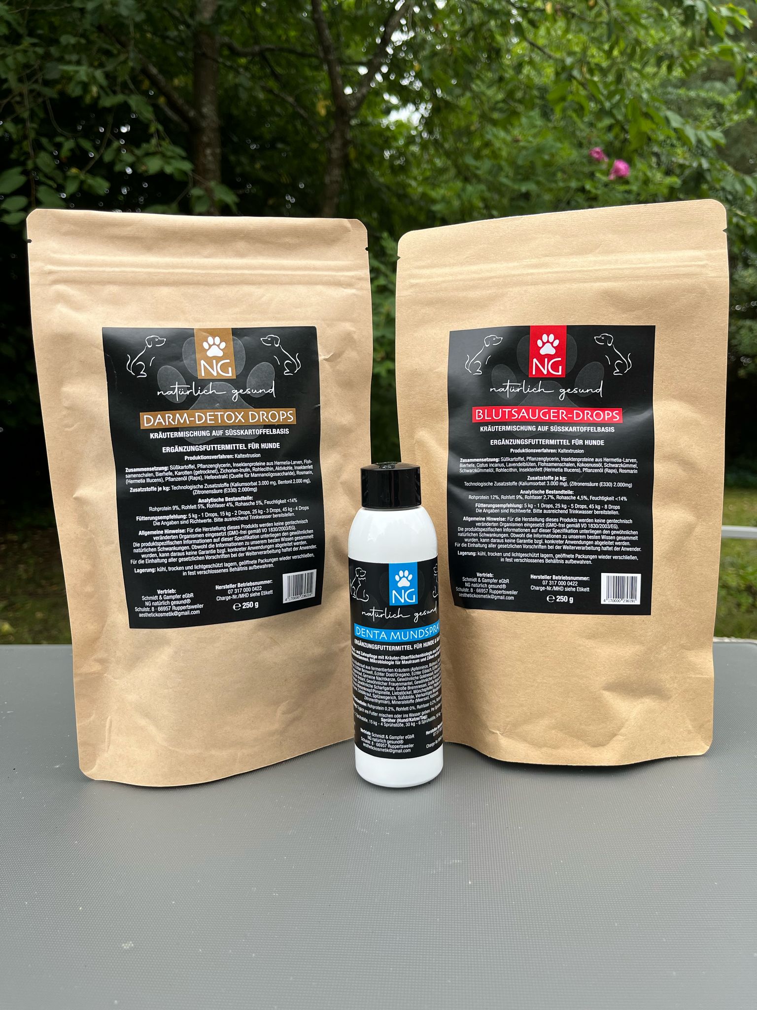 Bild mit den 3 Ergänzungsfuttermittel für Tiere, erste Packung Darm-Detox Drops, zweite Packung Blutsauger-Drops, und vorne steht die Flasche Denta Mundspray
